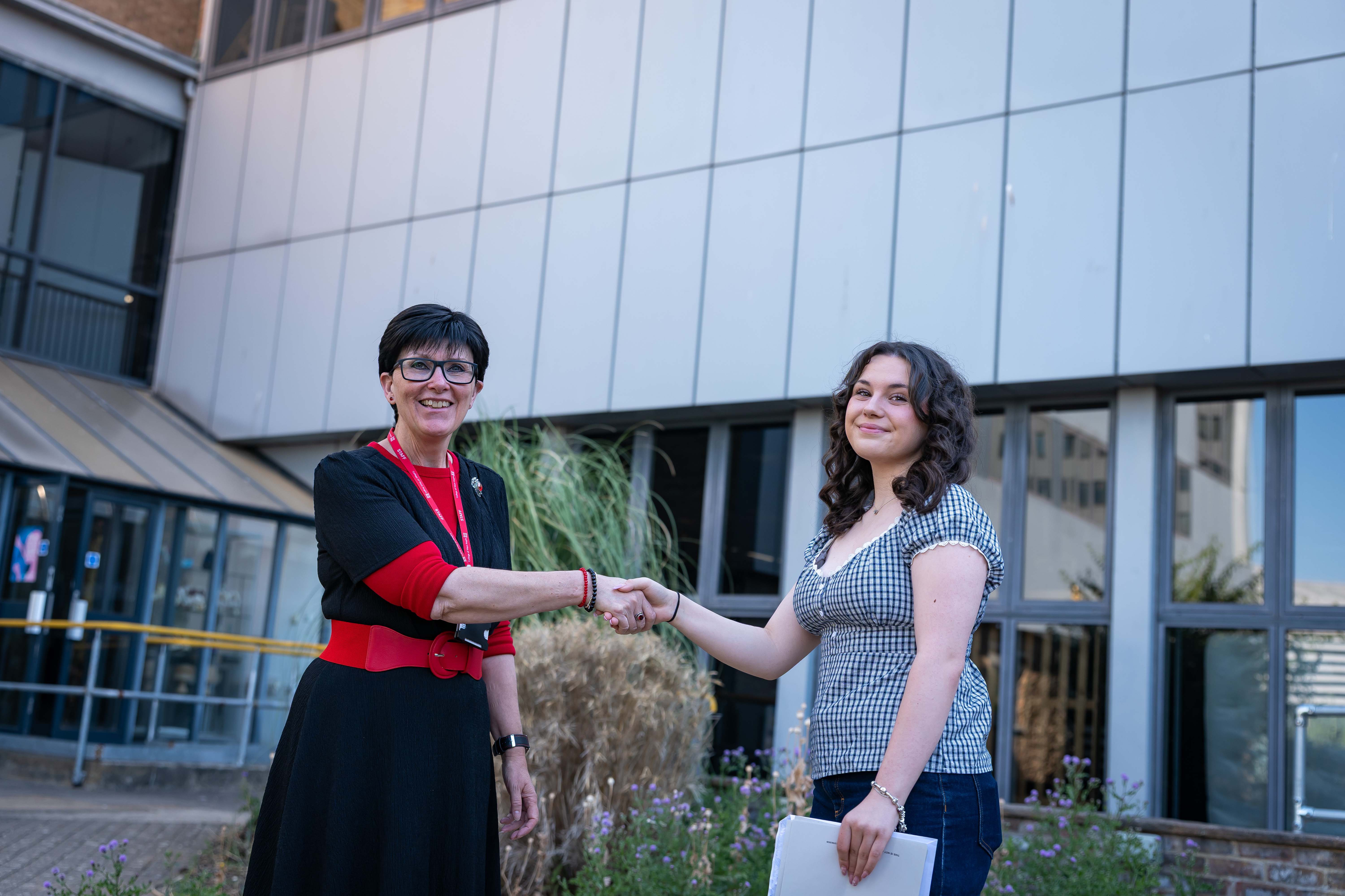 VP, Kerry shaking the hand of student holding her results